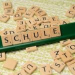 Kafelkowe literki układające się w niemieckie słowo Schule na stole