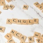 Kafle Scrabble układające się w niemieckie słowo Schule na marmurze