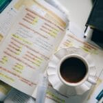 Kubek kawy stojący na odręcznych notatkach do nauki hiszpańskiego