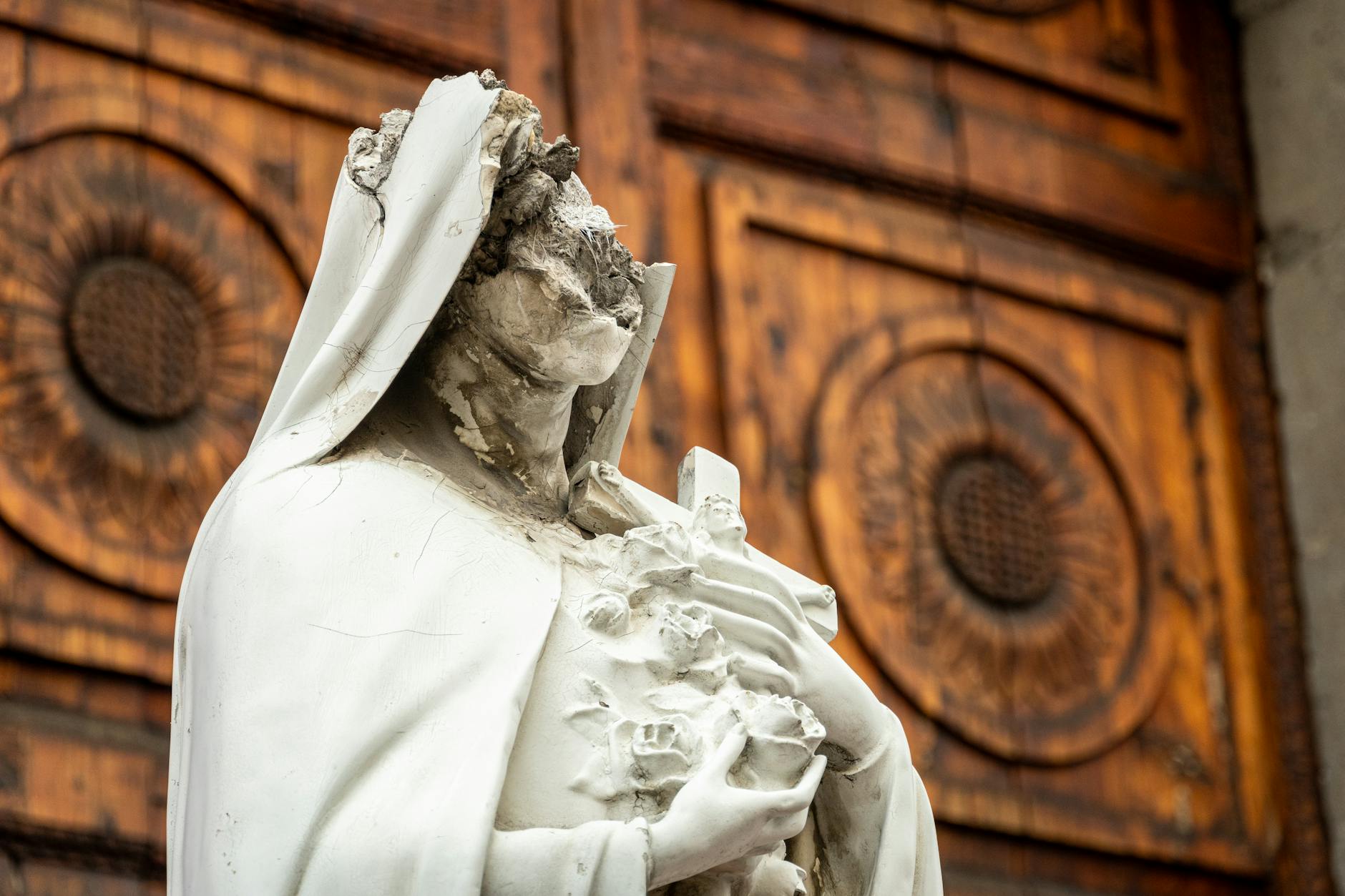 Zniszczona figura Matki Boskiej przed opuszczonym kościołem w Meksyku