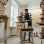 Rzeźbiarz afroamerykański modeluje popiersie z gliny w jasnej pracowni