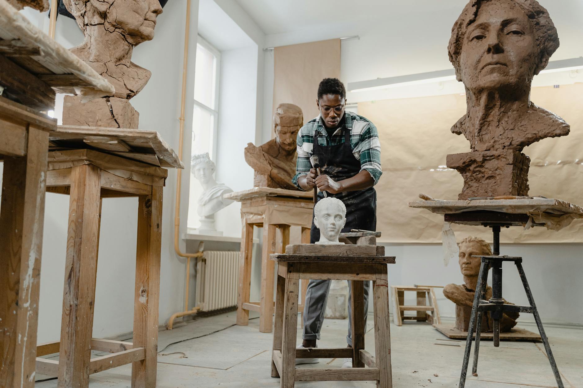 Rzeźbiarz afroamerykański modeluje popiersie z gliny w jasnej pracowni