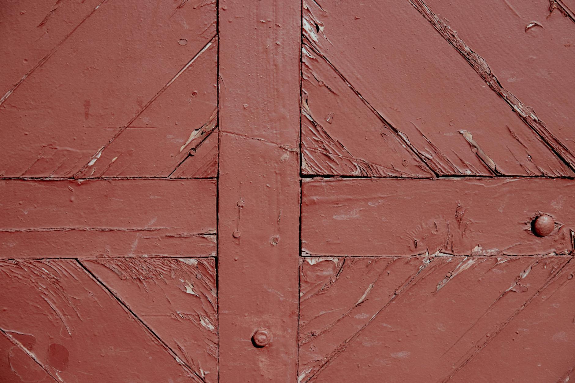 Zbliżenie czerwonej, spatynowanej deski z widocznym usłojeniem drewna